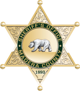 Gold, ornate six-pointed star badge with a bear in the center. Green border reads Sheriffs Office Madera County. The number 1893 is at the bottom point of the star.