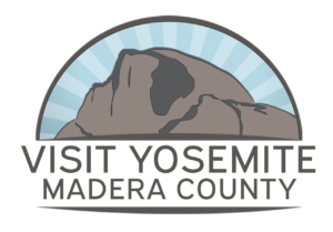 A stylized mountain illustration with sun rays behind it, above the text VISIT YOSEMITE MADERA COUNTY..
